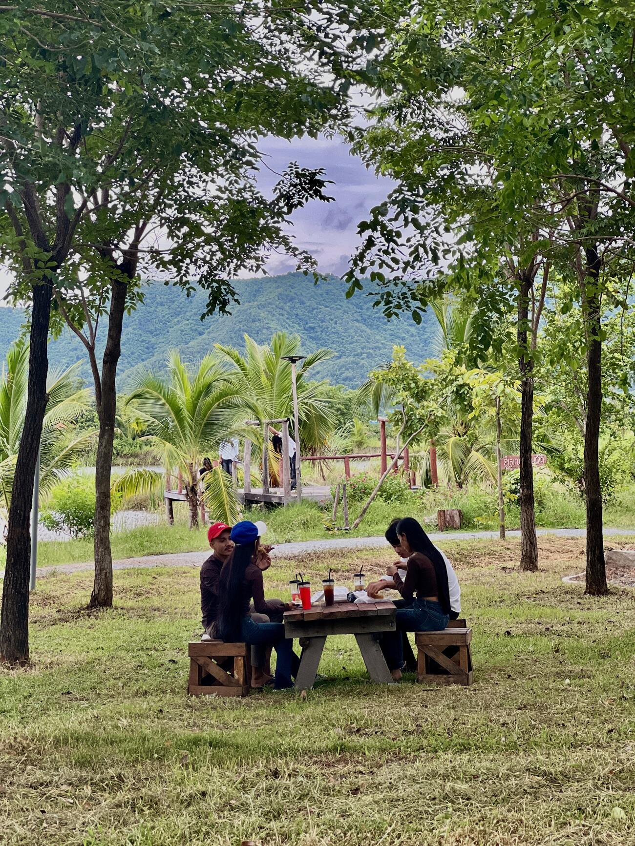 A family sharing a meal at the picnic table with mountains in the distance